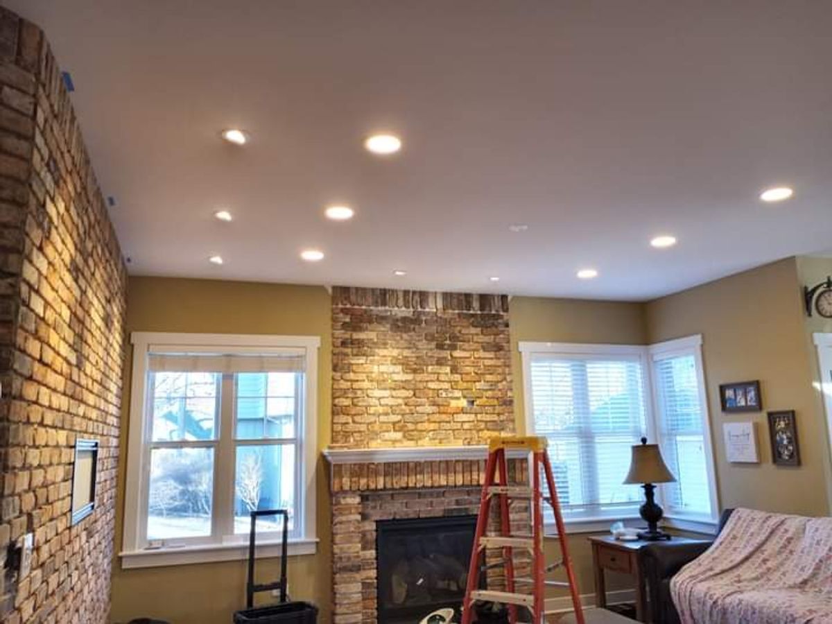 A living room with a fireplace and a ladder in it