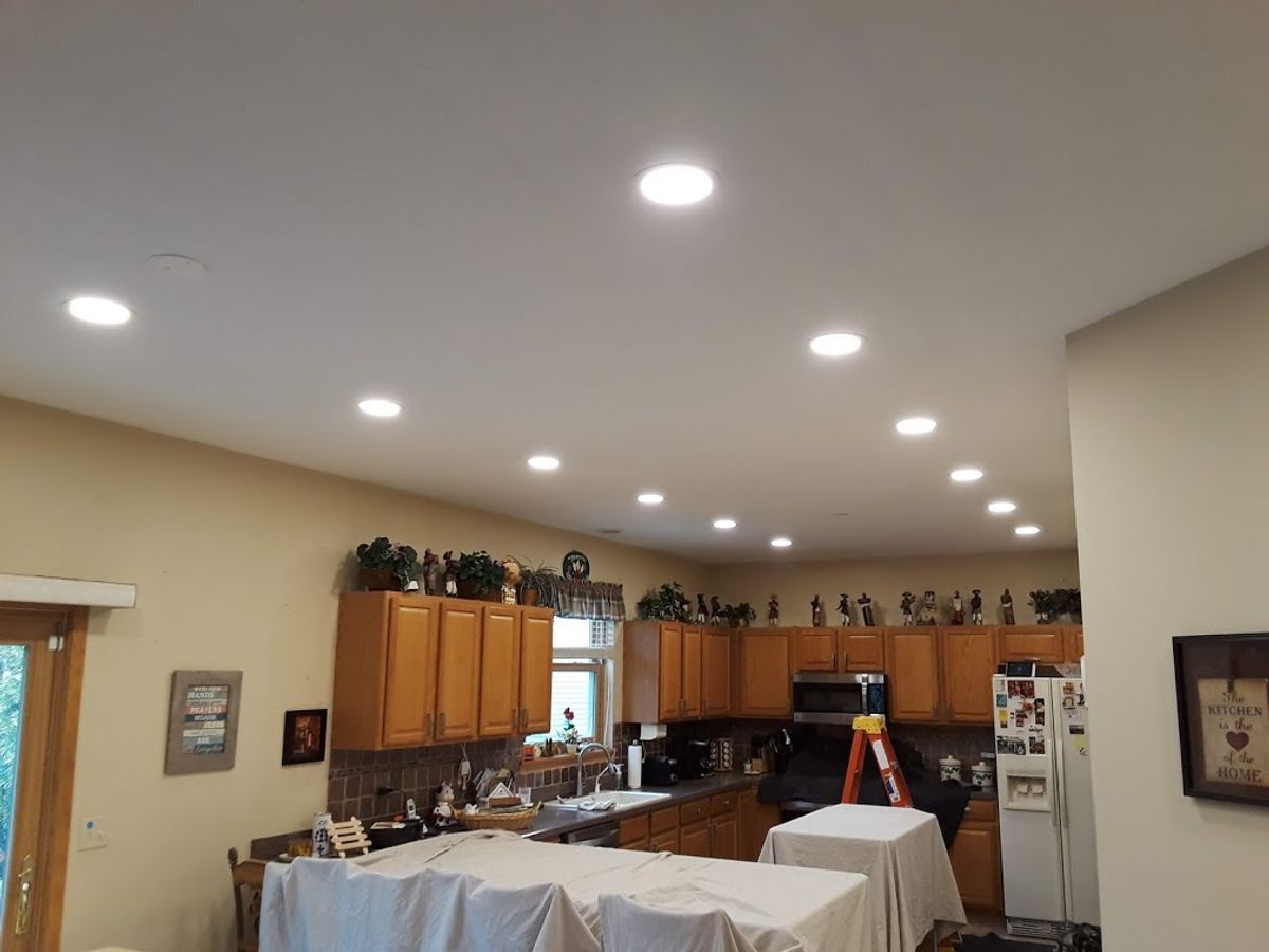 A kitchen with a lot of lights on the ceiling