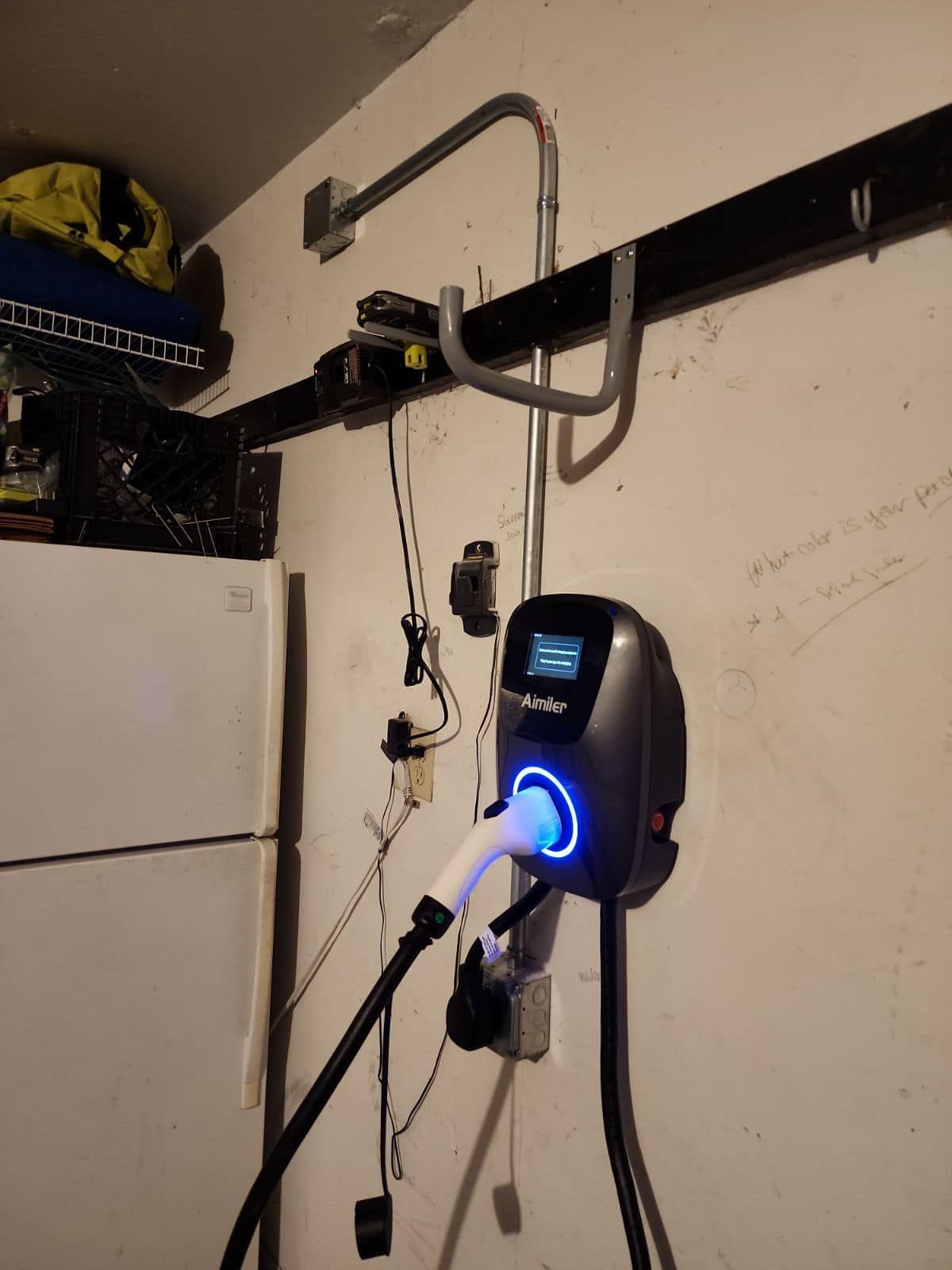 A charger is plugged into a wall next to a refrigerator