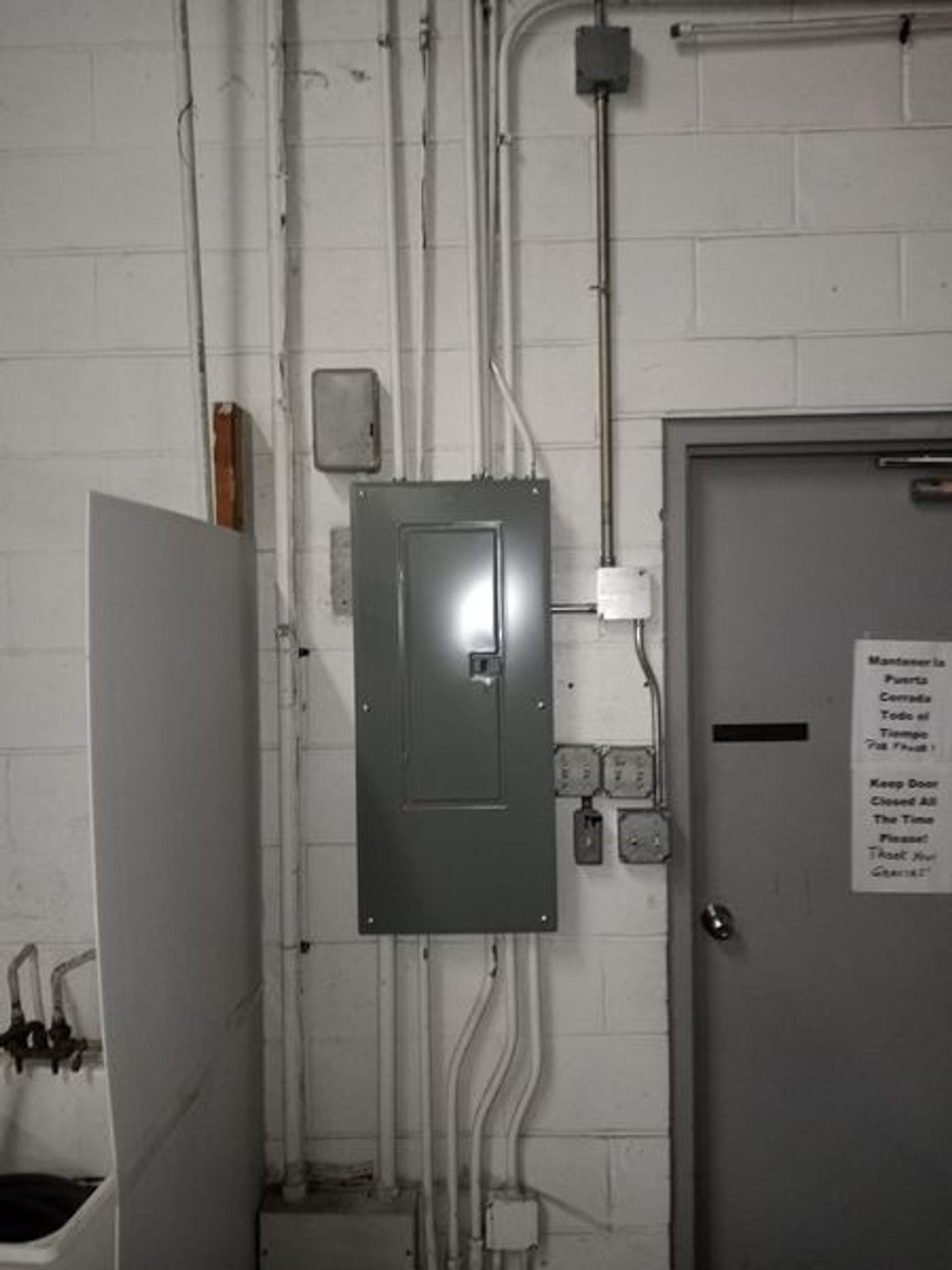 There is a electrical box on the wall next to a door.