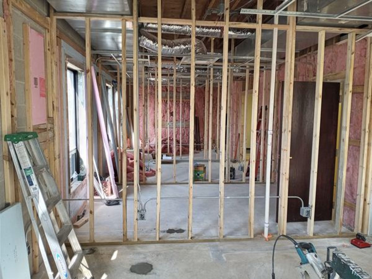 A room is being built with wooden beams and a ladder.