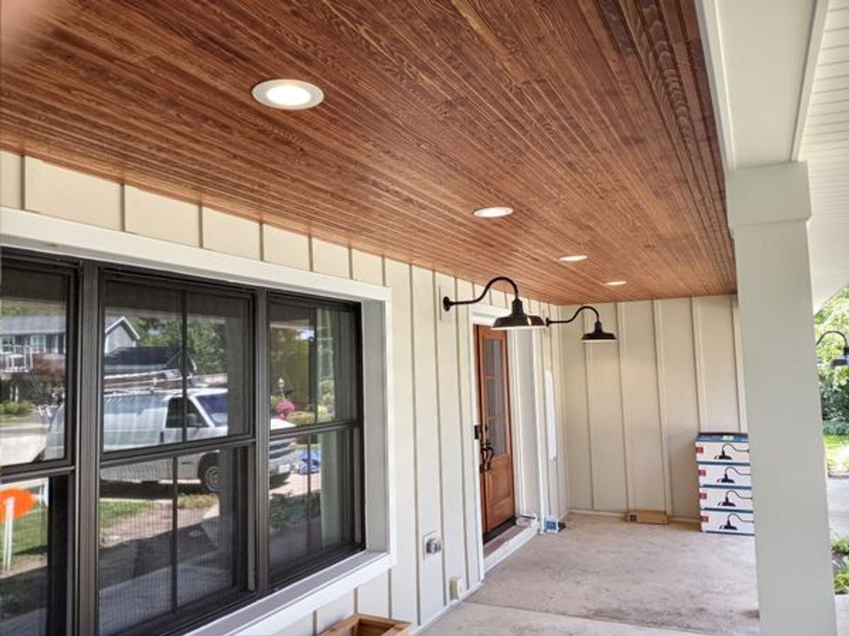 A porch with a wooden ceiling and a window.