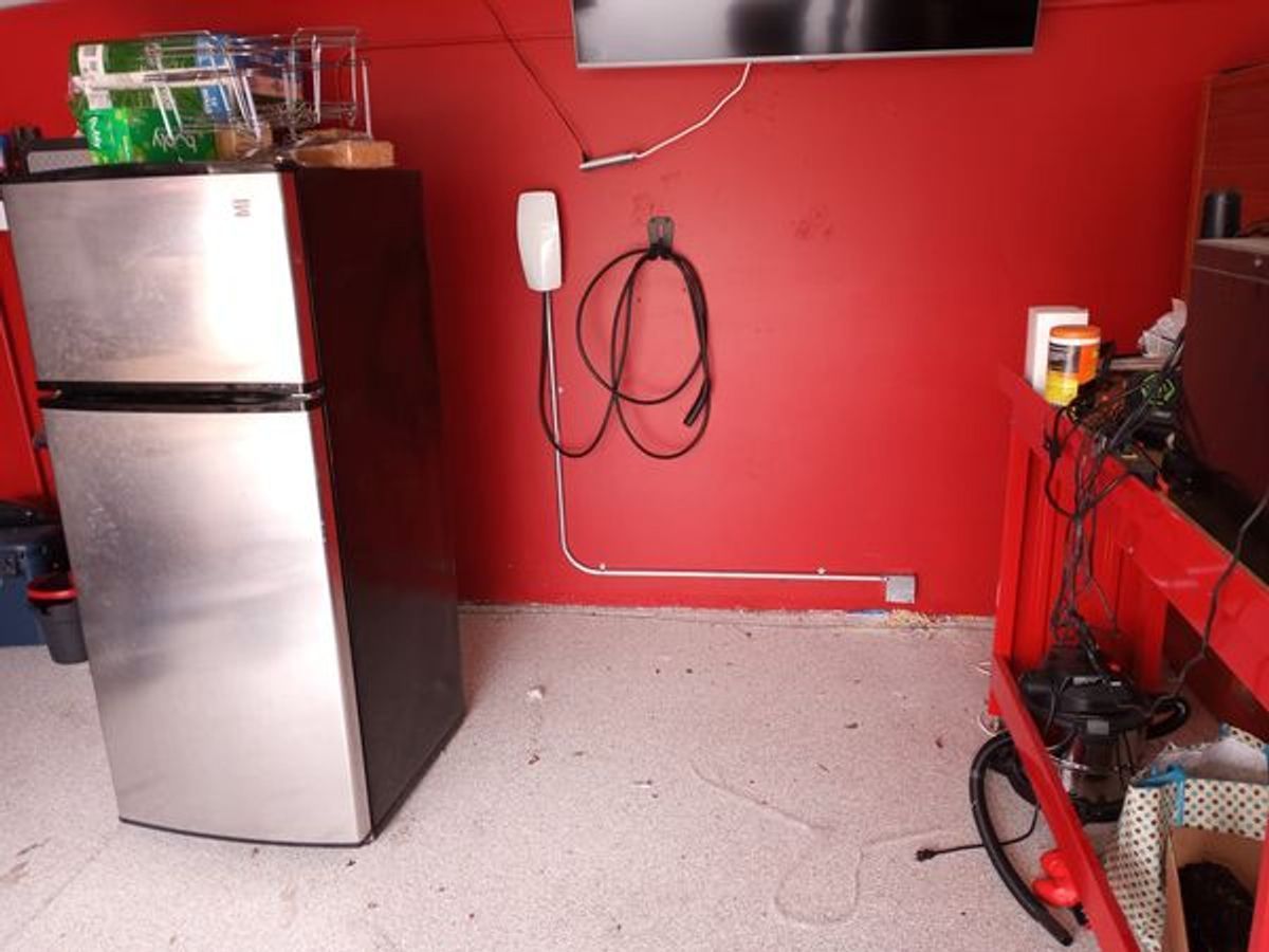 A stainless steel refrigerator is in a room with a red wall