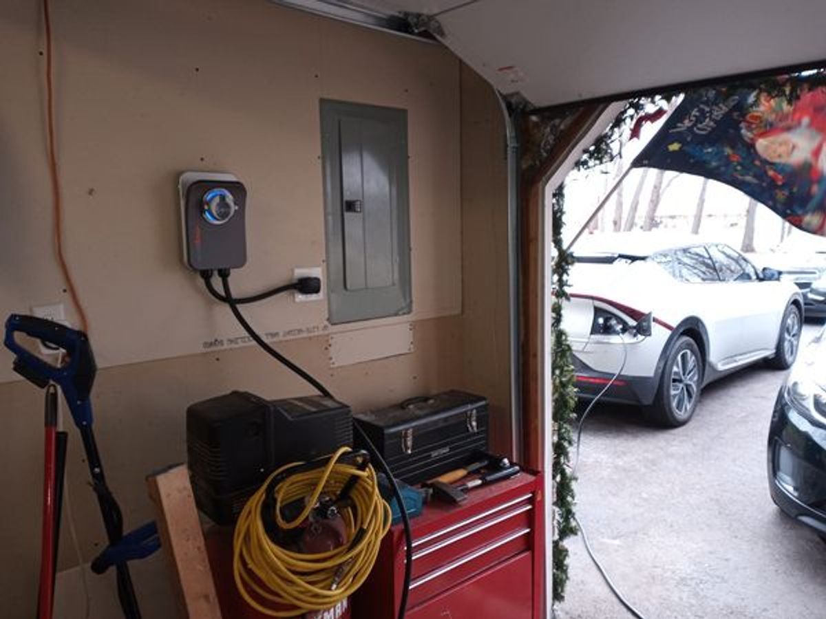 A white car is being charged in a garage.