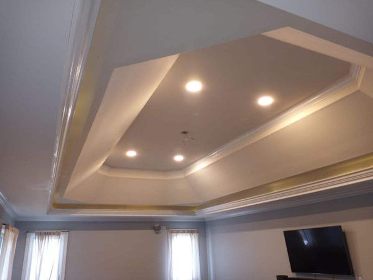 A living room with a ceiling that has lights on it