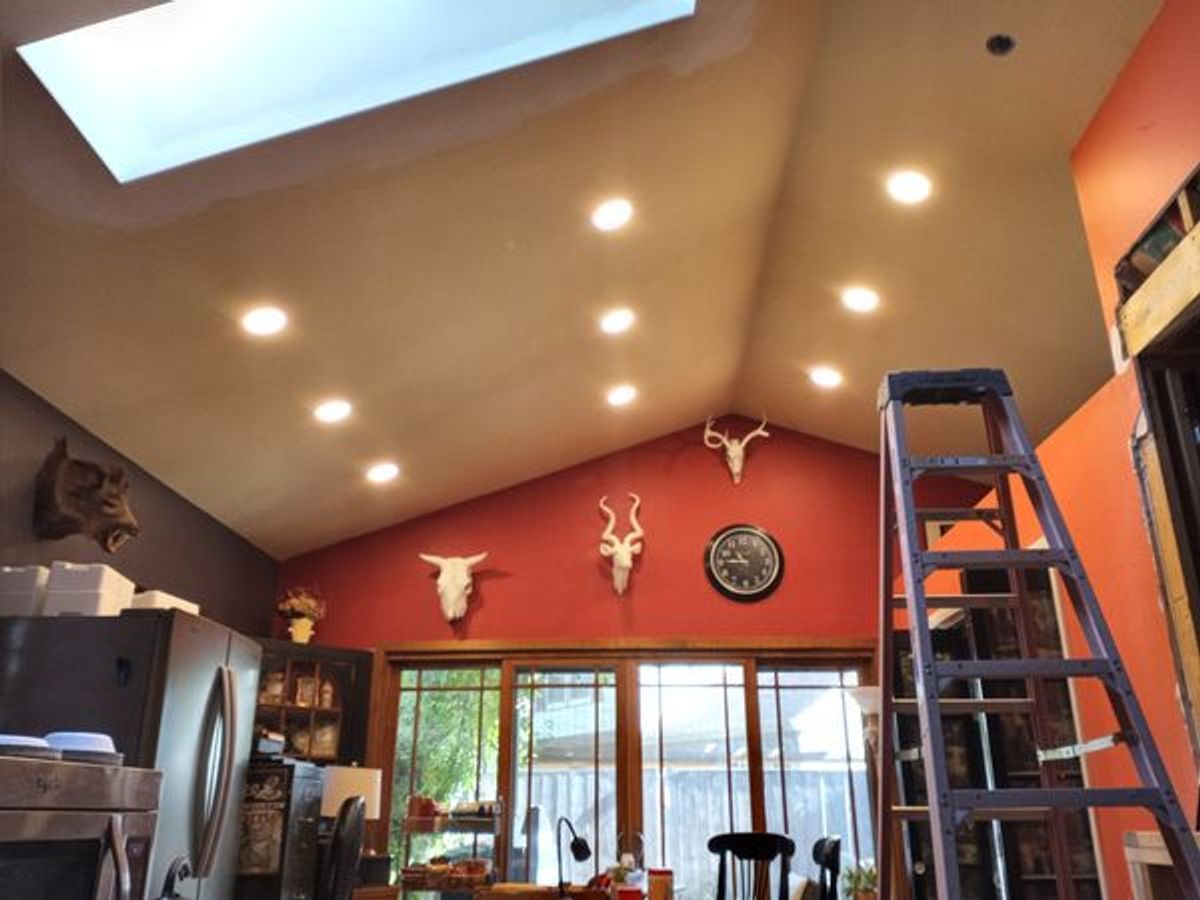A living room with a skylight and a ladder