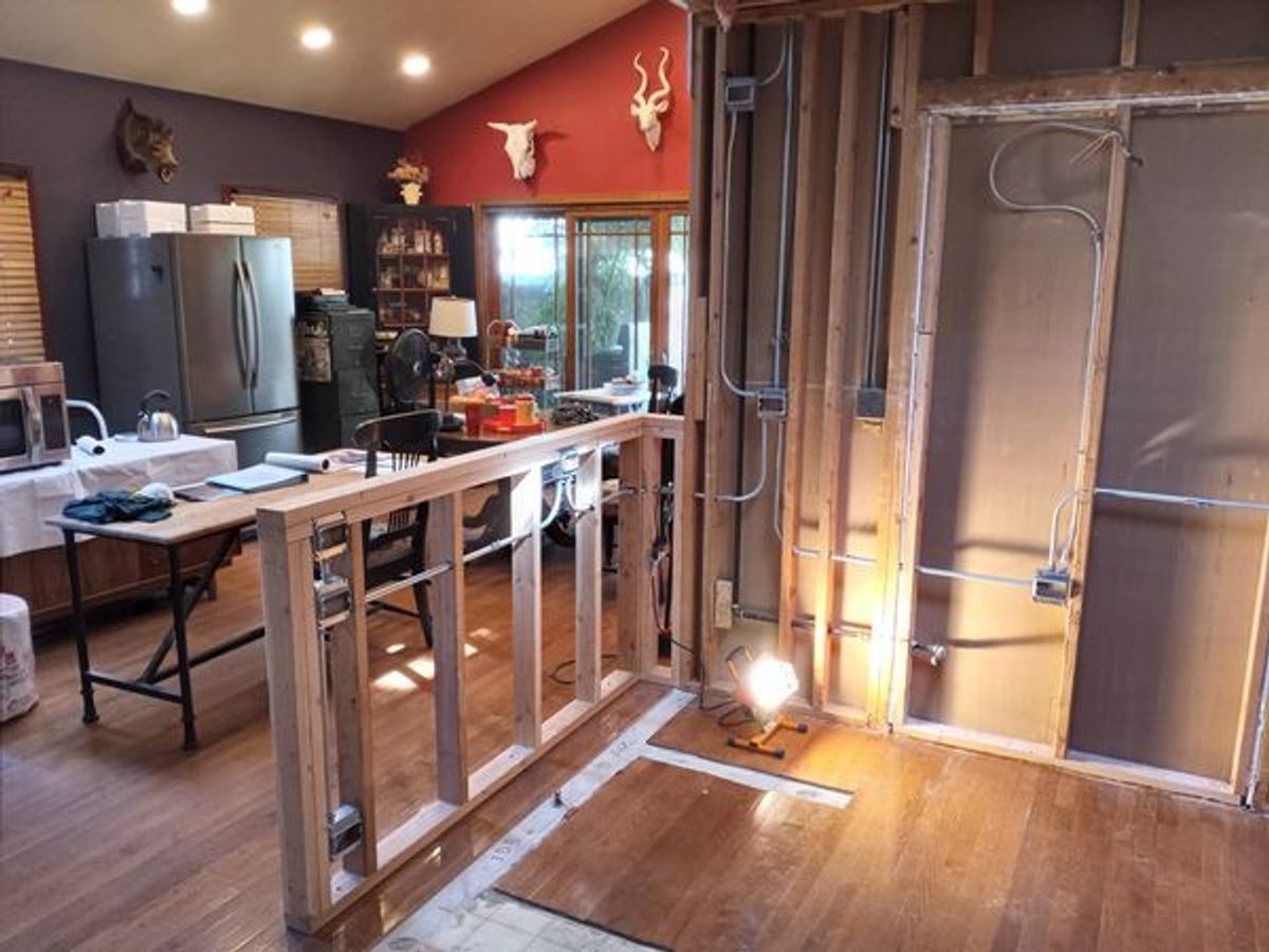 A kitchen that is being remodeled with wooden walls