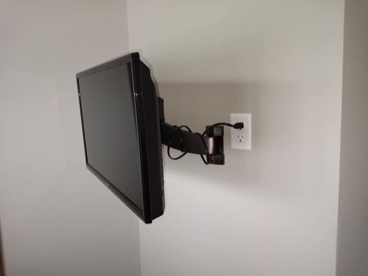 A flat screen tv mounted on a wall next to a socket