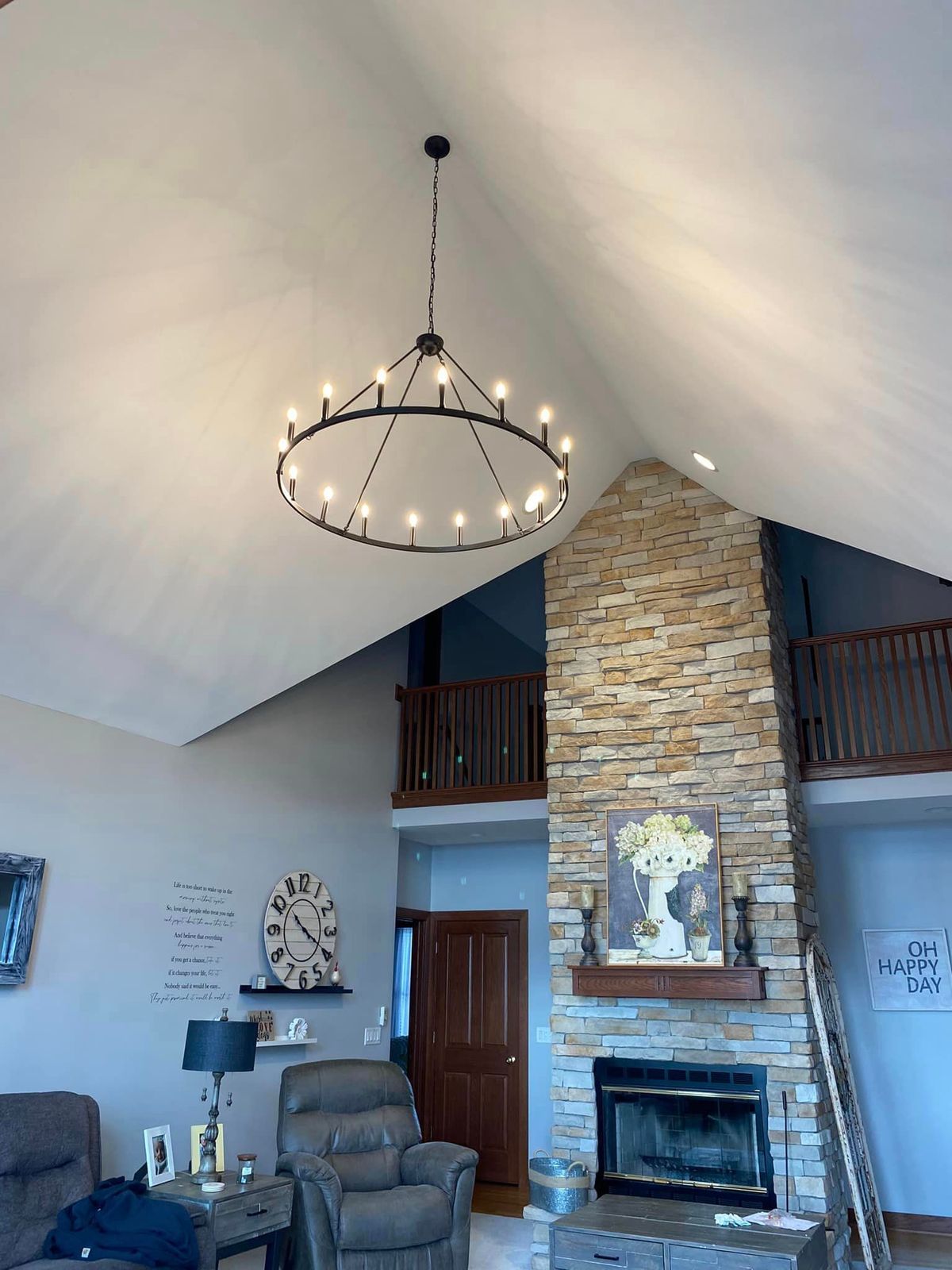 A living room with a fireplace and a chandelier hanging from the ceiling.