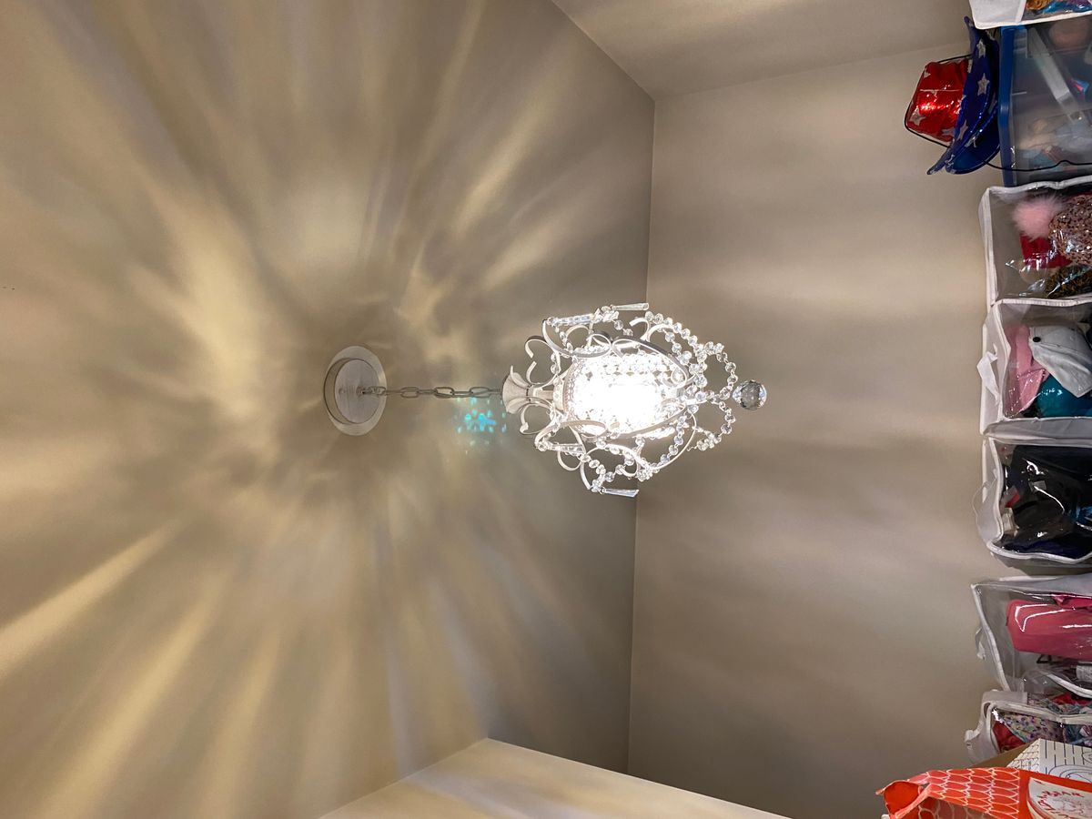 A light fixture is hanging from the ceiling in a closet.