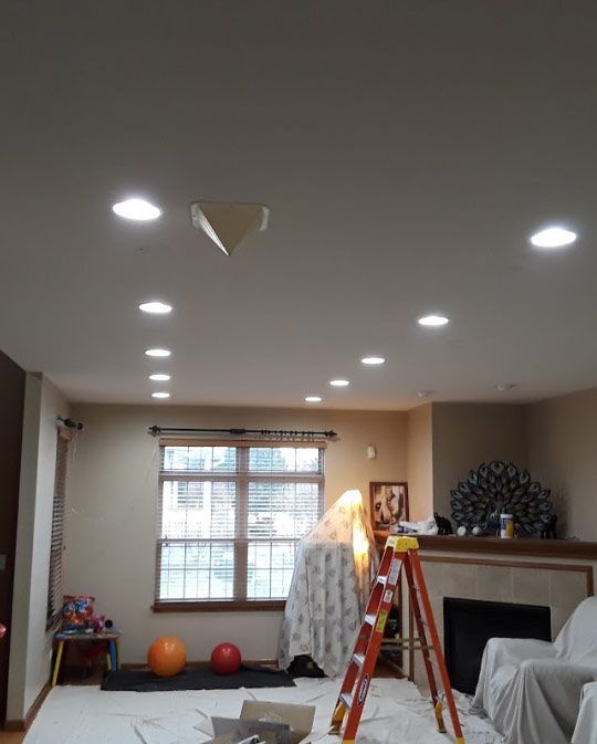 A living room with a ladder in the middle of it