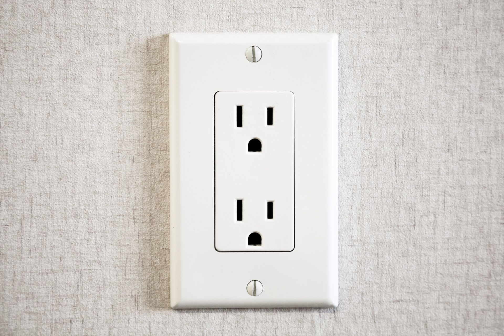 A close up of a white electrical outlet on a wall