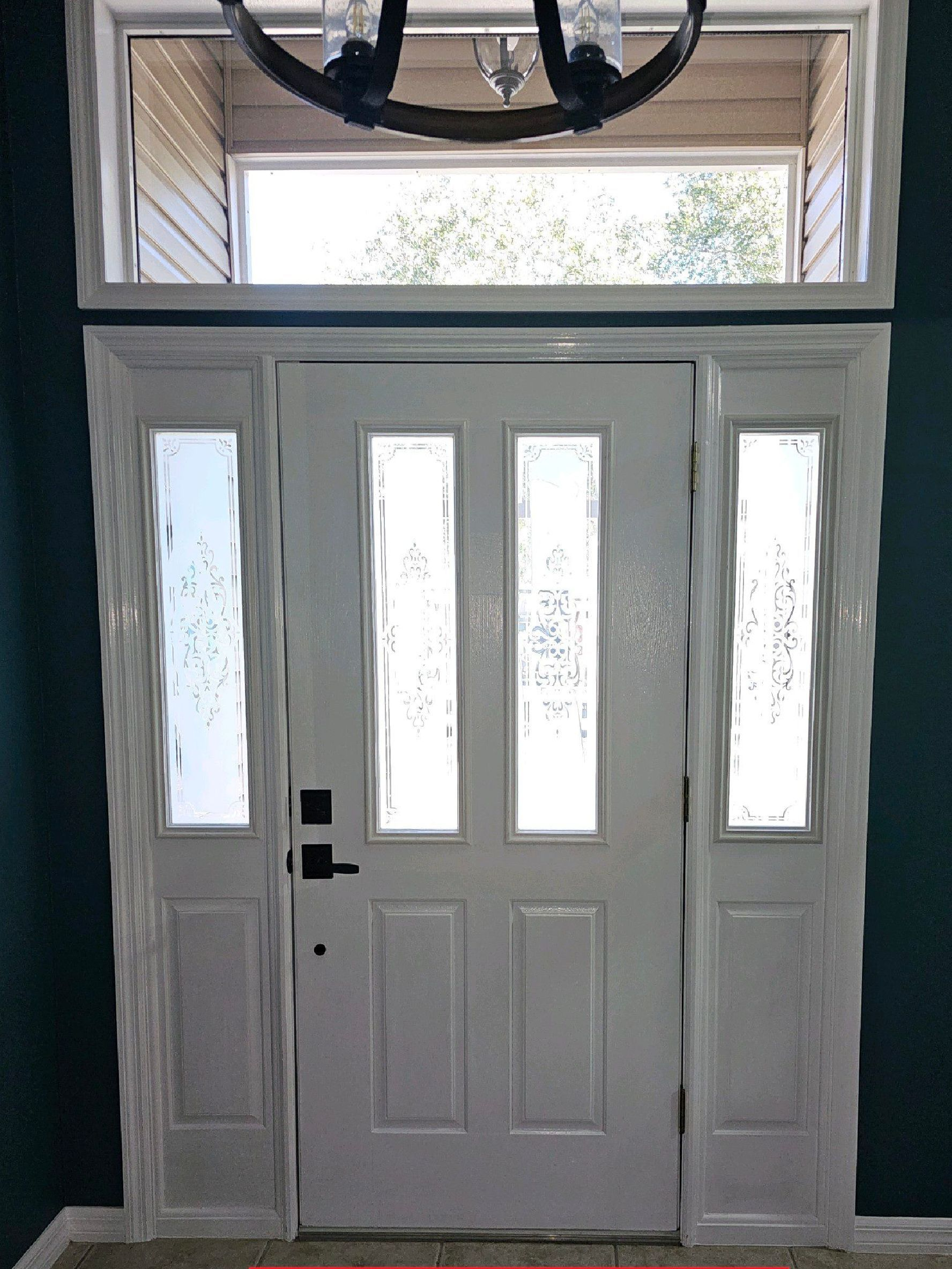 White front door with sidelights and transom window; interior view.