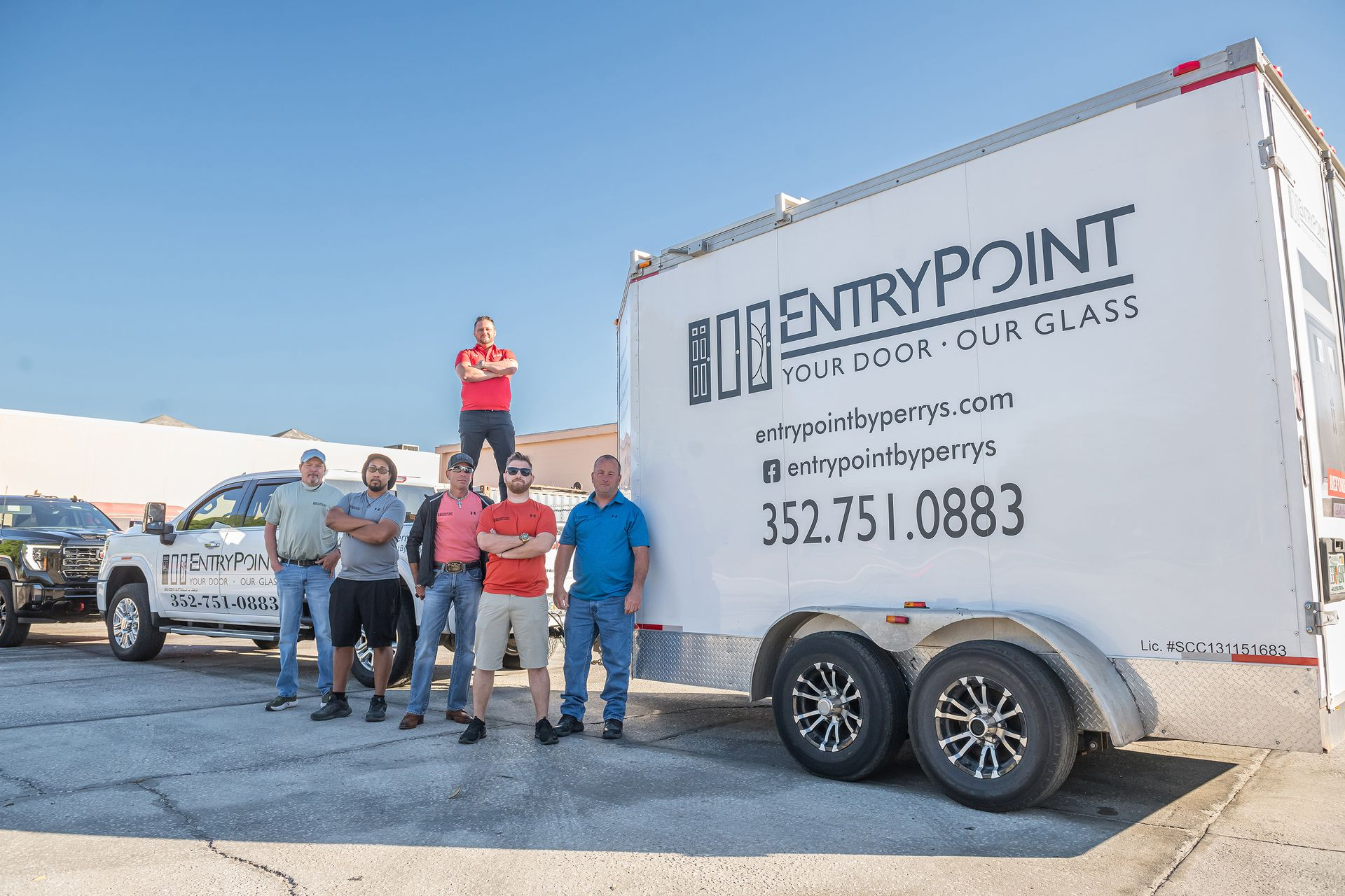 Group of men posing by a trailer with 