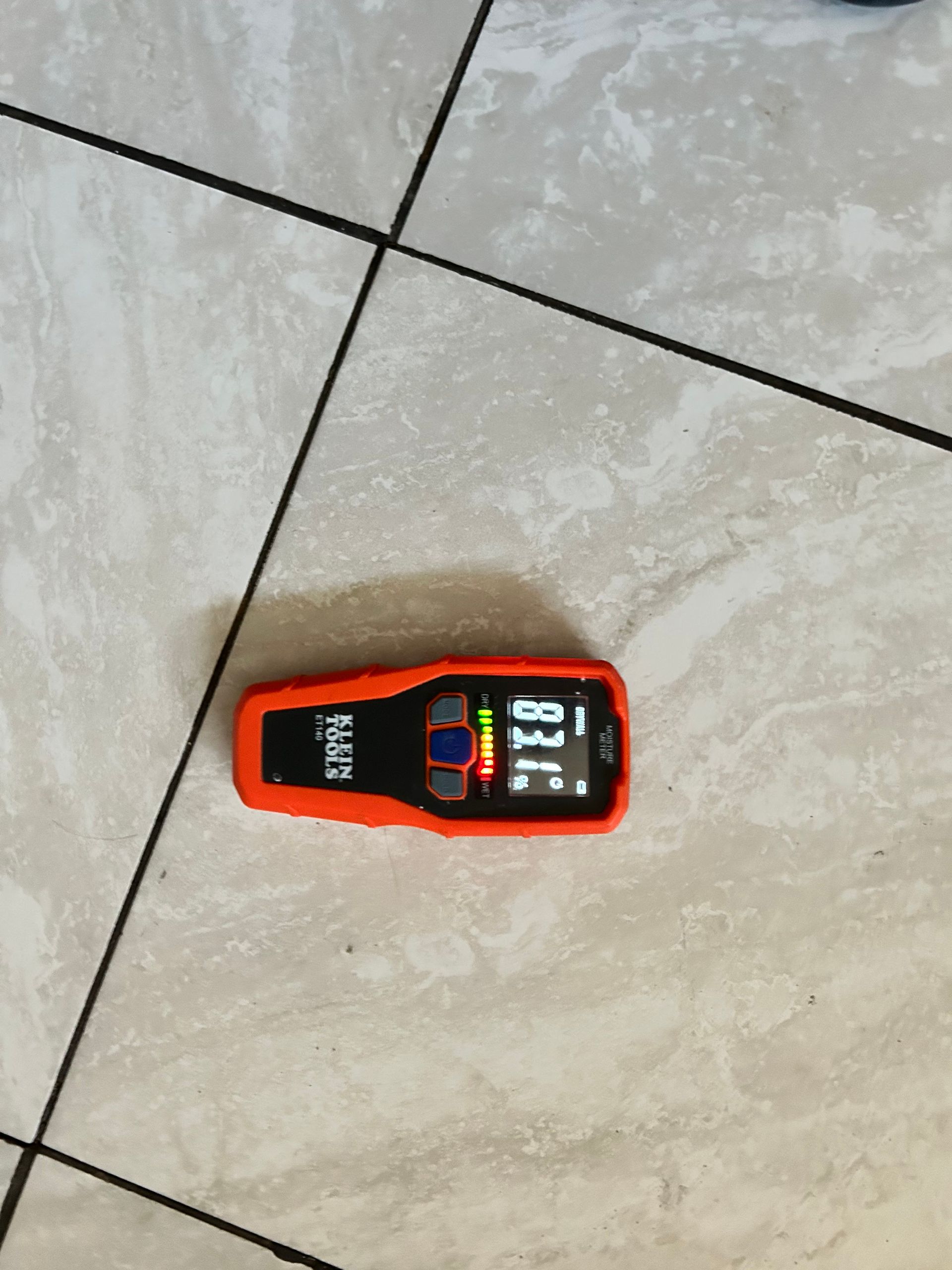 A klein tool is sitting on a tiled floor