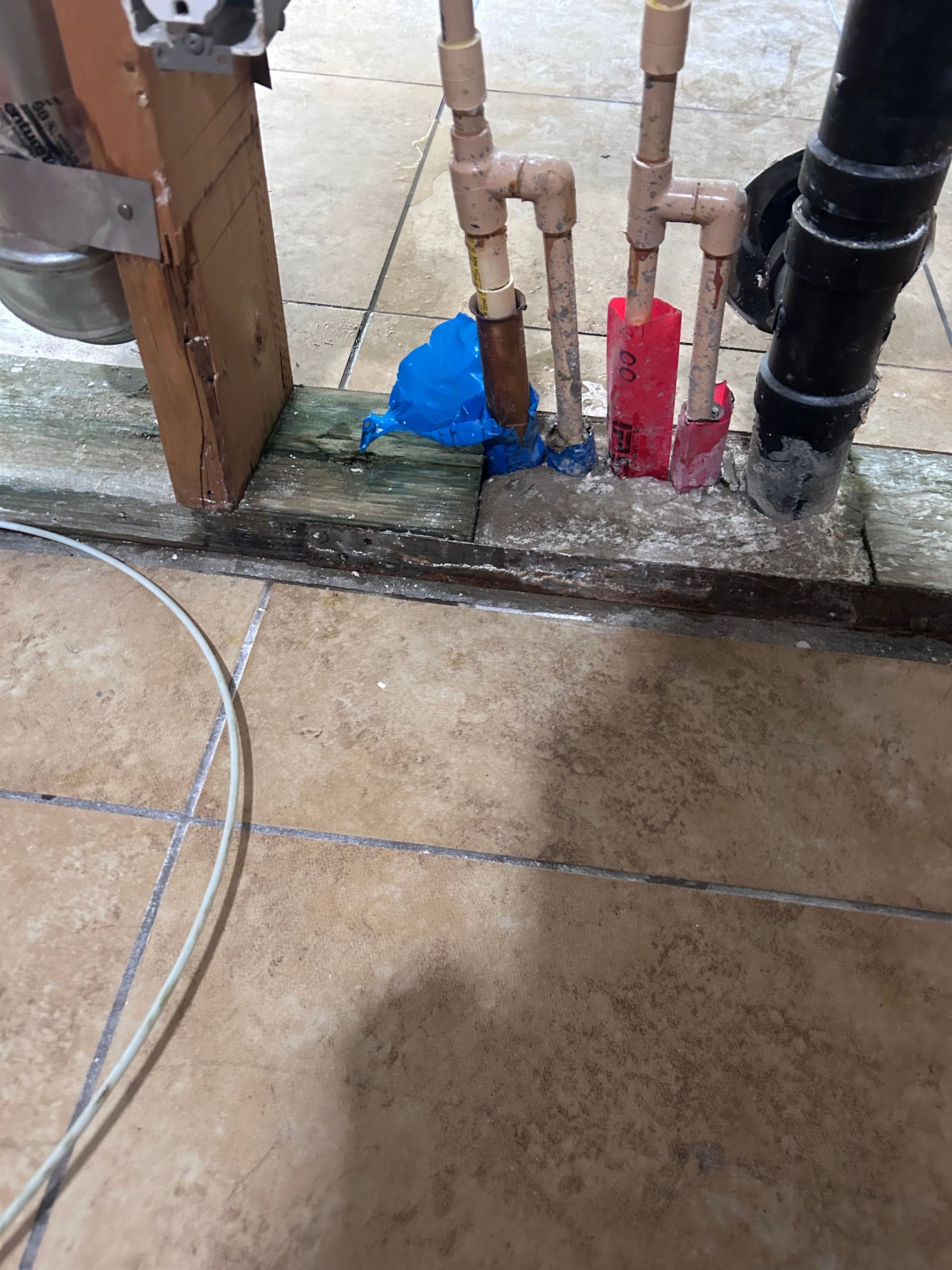 A bunch of pipes are sitting on the floor next to a door.