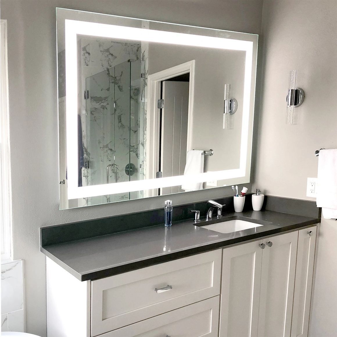 A bathroom with a sink , mirror and cabinets