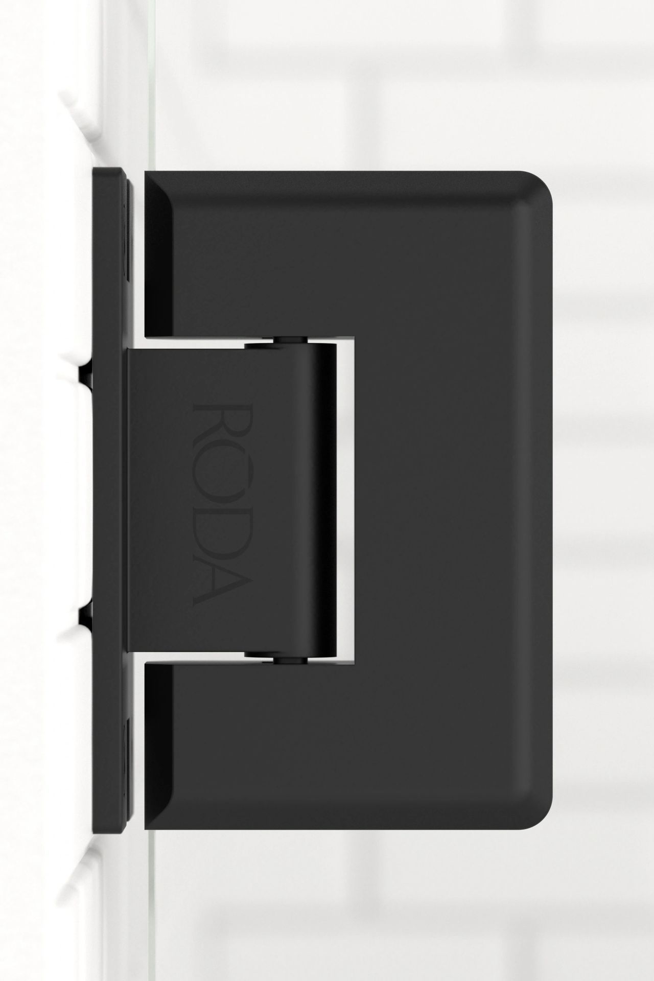 A black door hinge is sitting on a white wall.