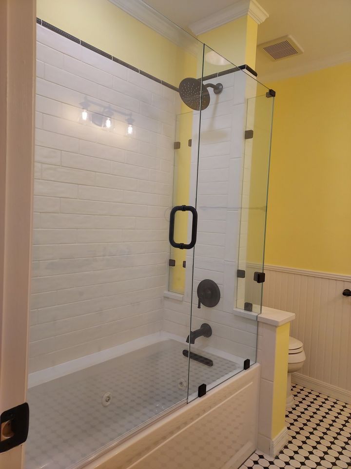 A bathroom with a tub and a shower with a glass door
