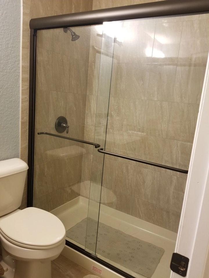 A bathroom with a toilet and a shower with a glass door