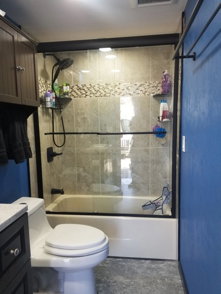 A bathroom with a toilet , tub and shower.