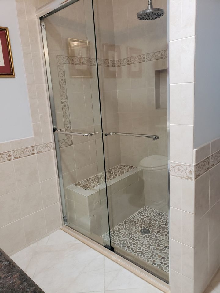 A bathroom with a sliding glass shower door and a toilet.