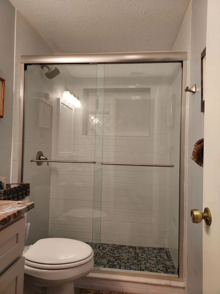 A bathroom with a toilet and a glass shower door
