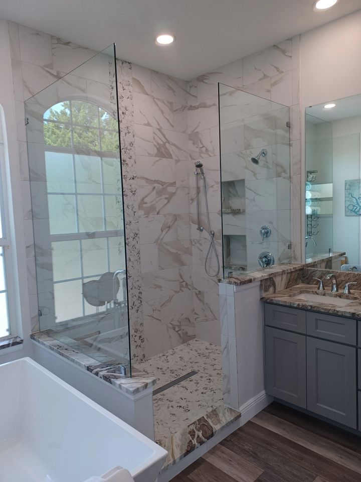 A bathroom with a walk in shower , sink , and bathtub.