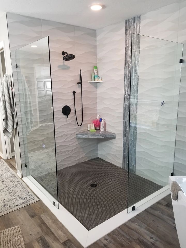 A bathroom with a walk in shower and a sink.