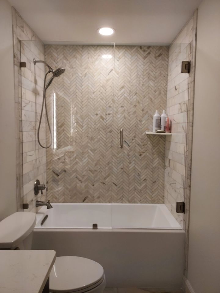 A bathroom with a tub , toilet and shower.