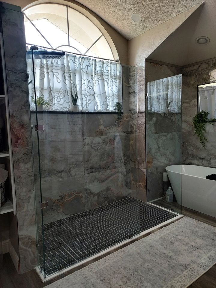 A bathroom with a walk in shower and a bathtub.