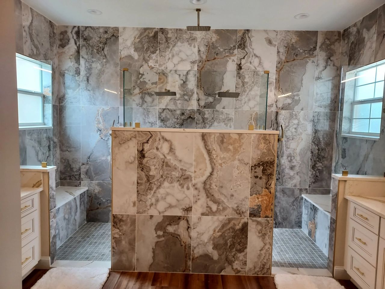A bathroom with marble tiles and a walk in shower.