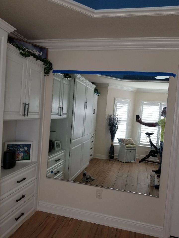 A large mirror is hanging on a wall in a room.