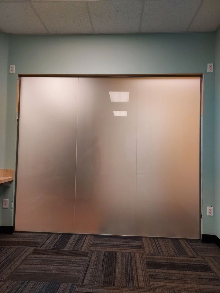 A room with a large glass wall and a carpeted floor.