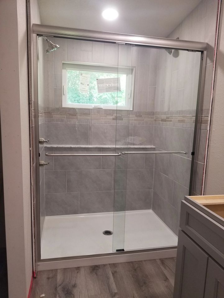 A bathroom with a sliding glass shower door and a sink.
