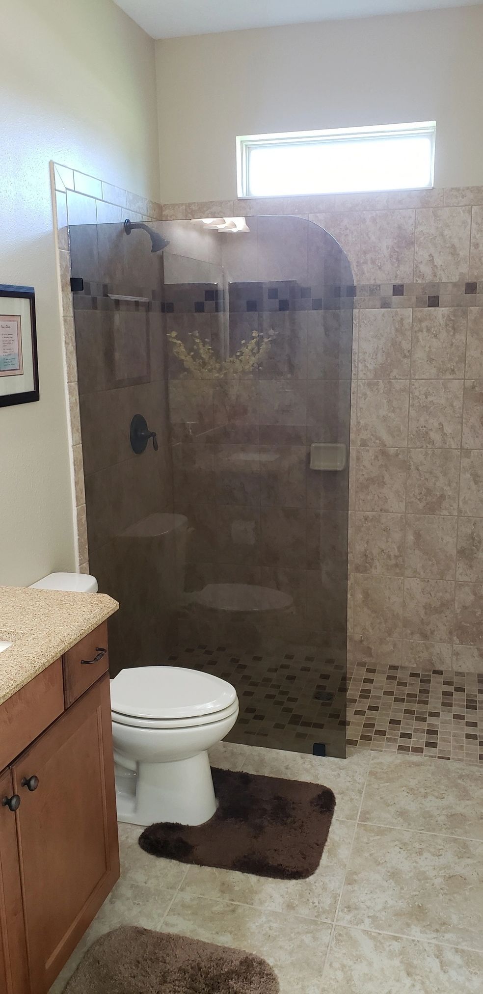 A bathroom with a toilet , sink , and walk in shower.