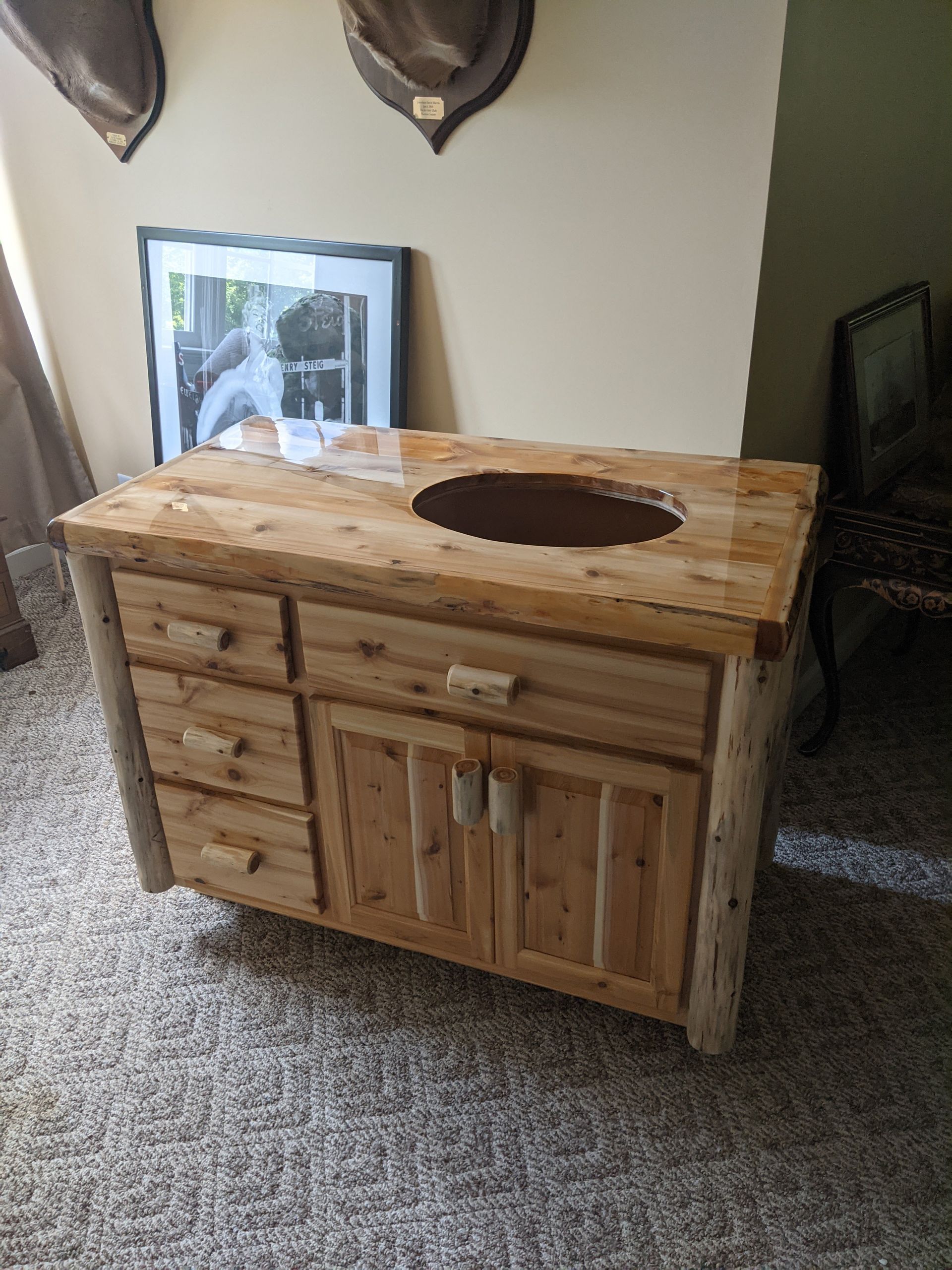 Rustic wooden bathroom vanity with a live-edge countertop and inset sink, positioned in a room with carpeted flooring.