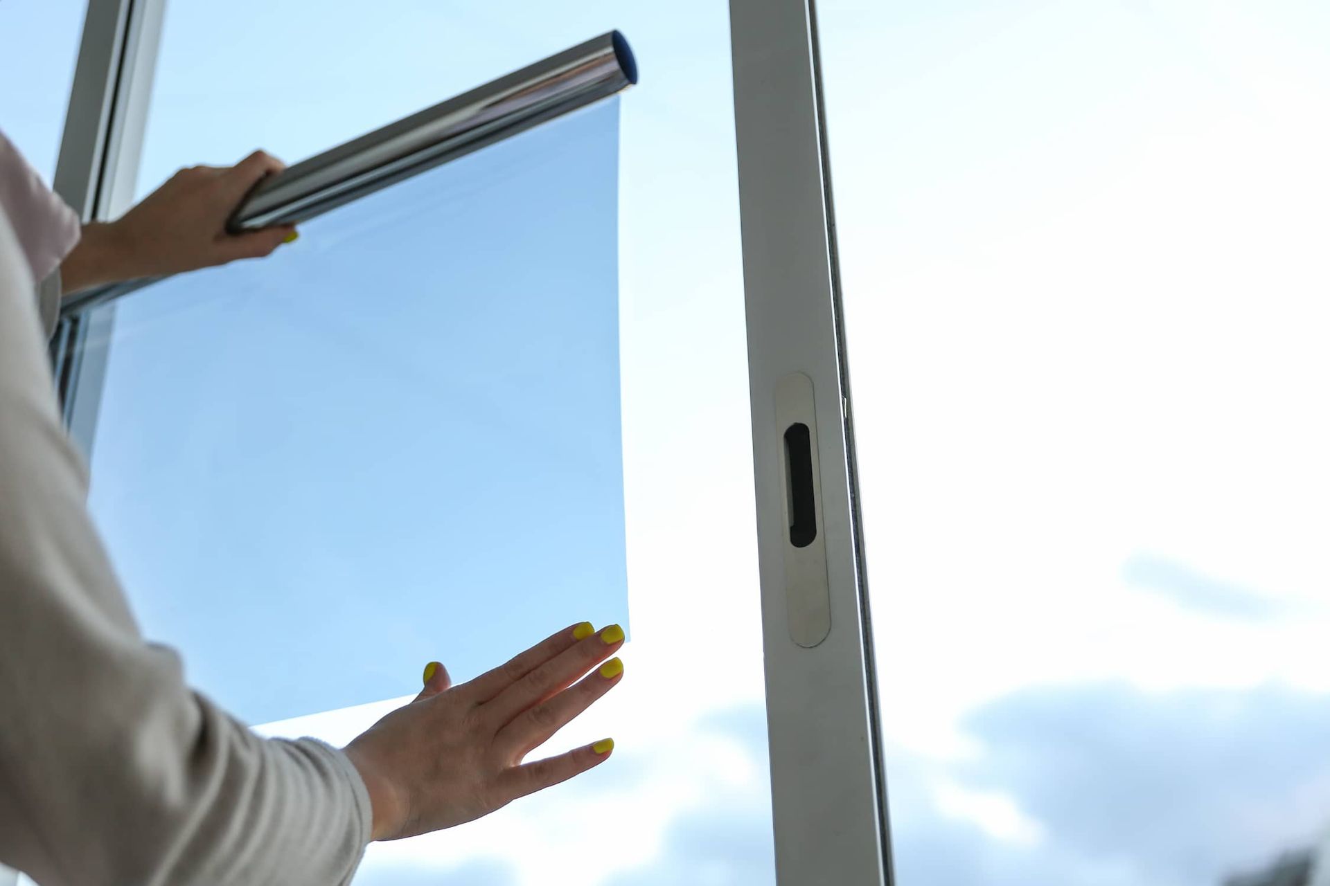 a Woman is Installing a Window Film on a Window — Total Tint Bendigo in East Bendigo, VIC