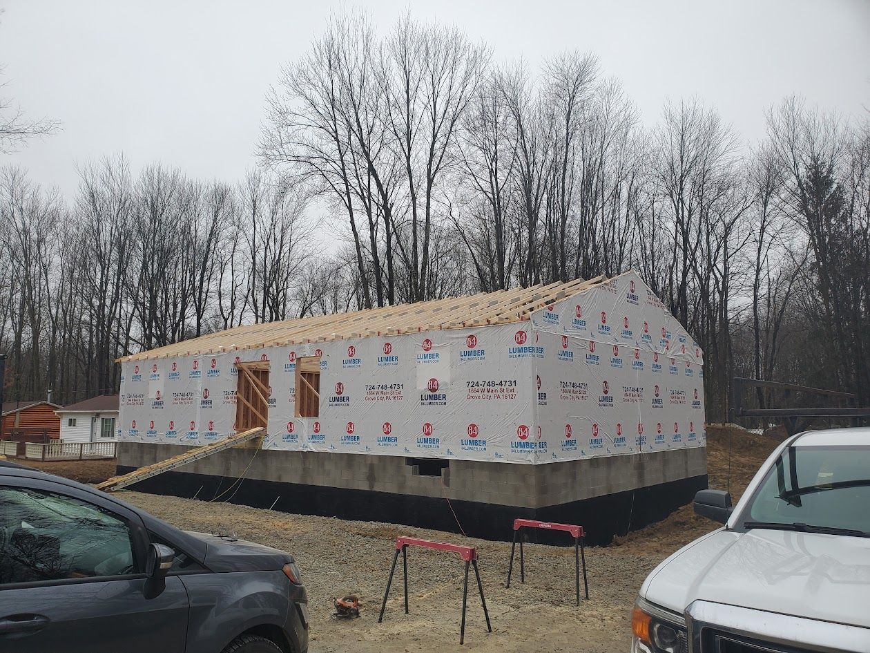 A car is parked in front of a building under construction.