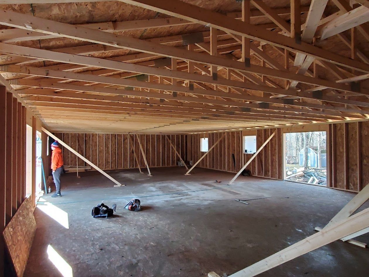 A man is standing in the middle of a room under construction.