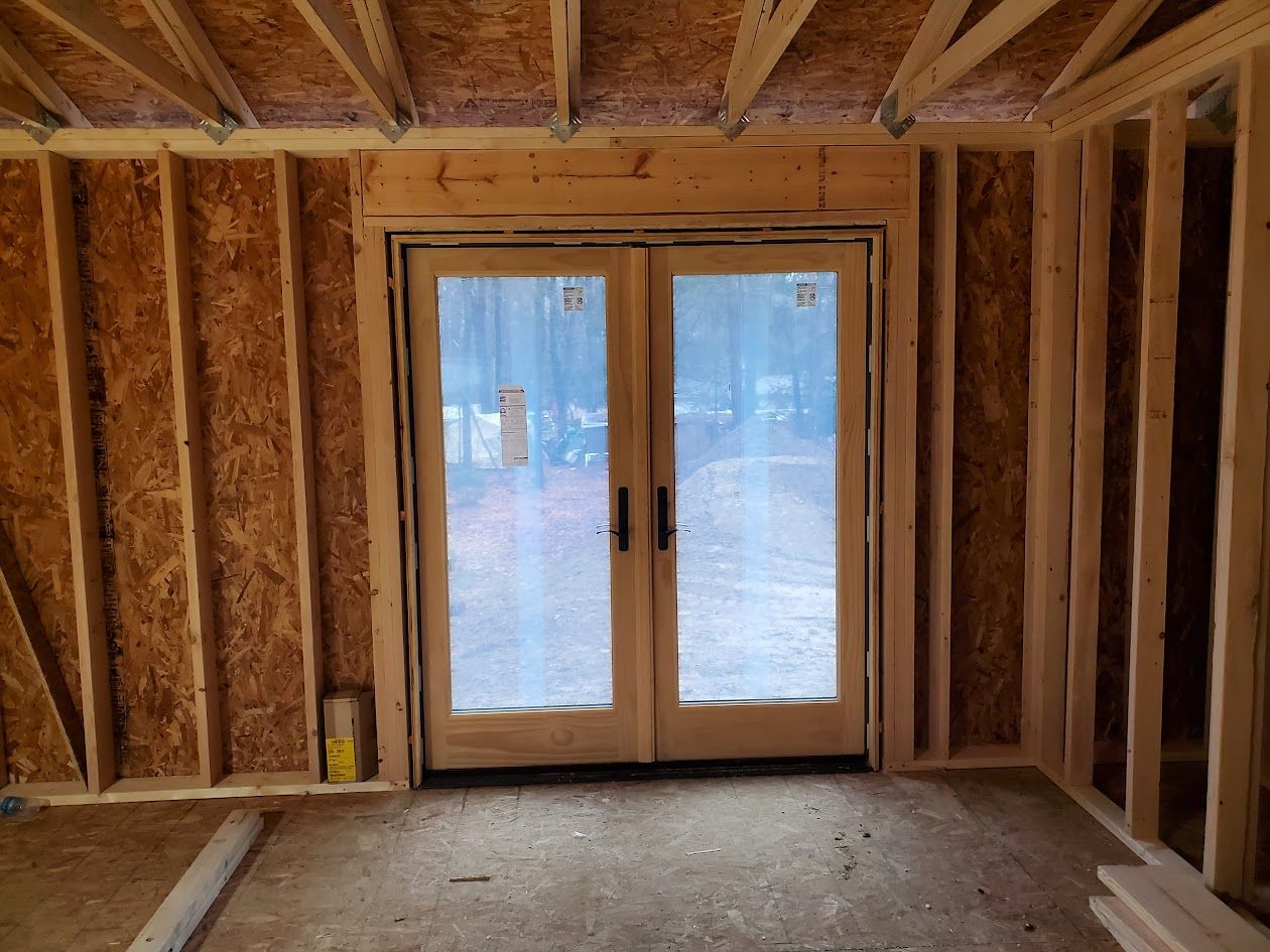 A room in a house under construction with a sliding glass door.