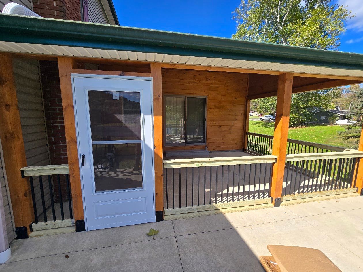 A wooden house with a porch and a white door.