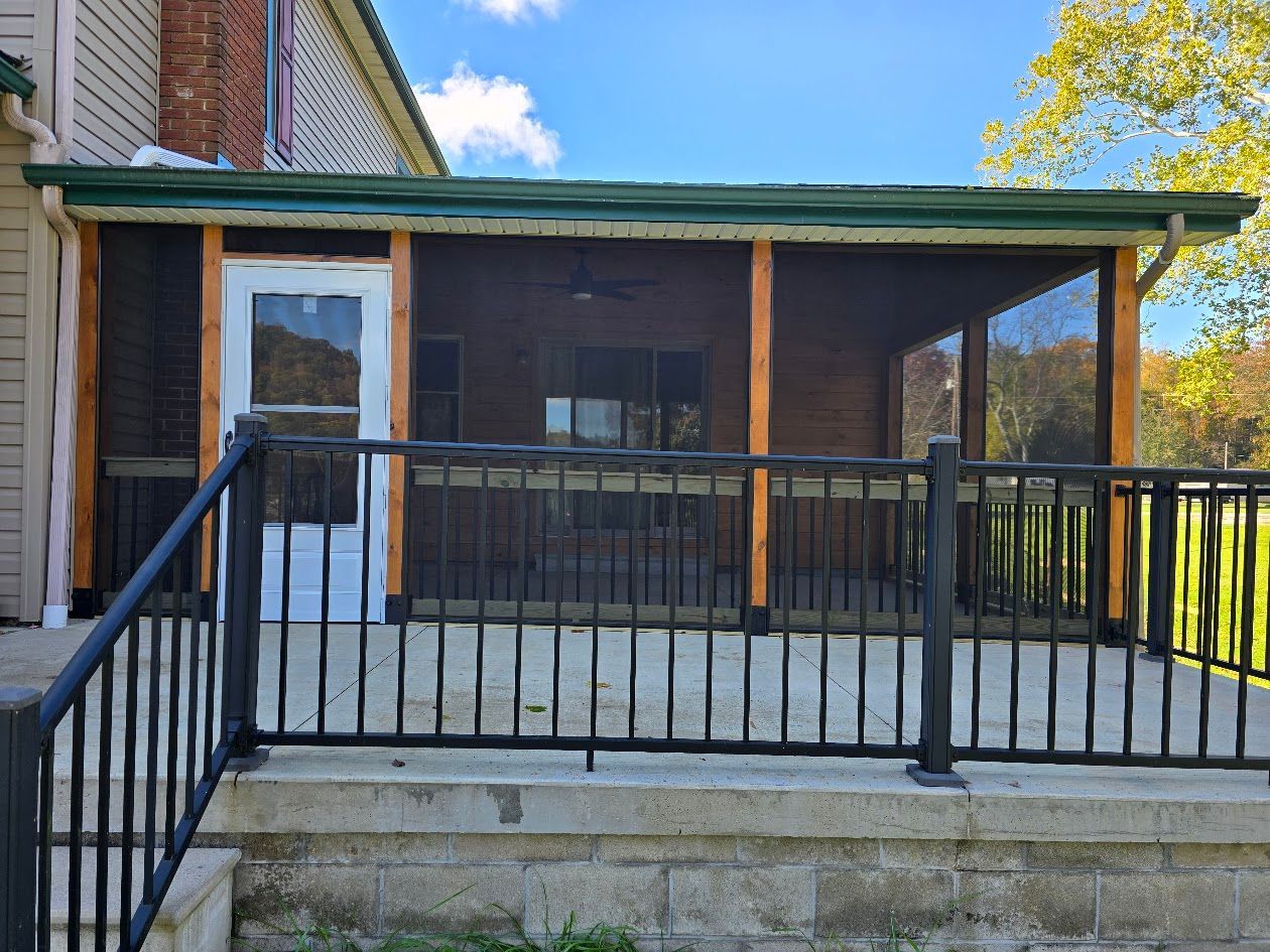 A screened in porch with a metal railing and stairs leading to it.