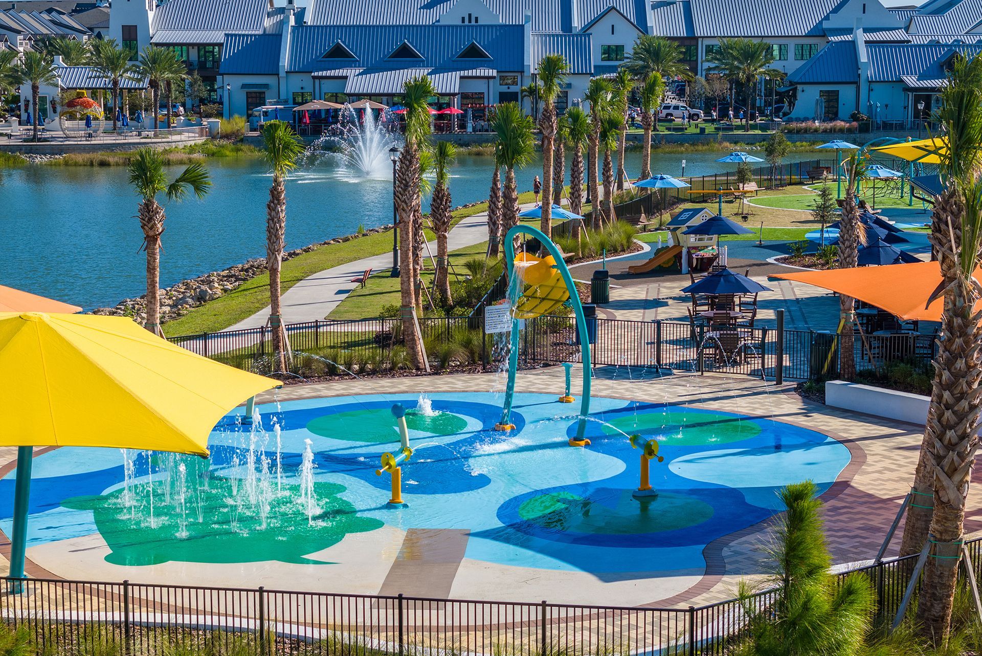 An aerial view of a water park with umbrellas and a fountain.