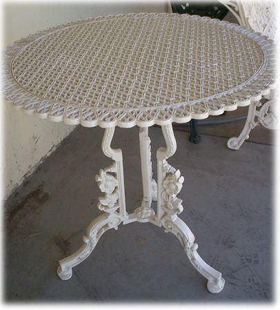 A white table with a wicker top is on a porch