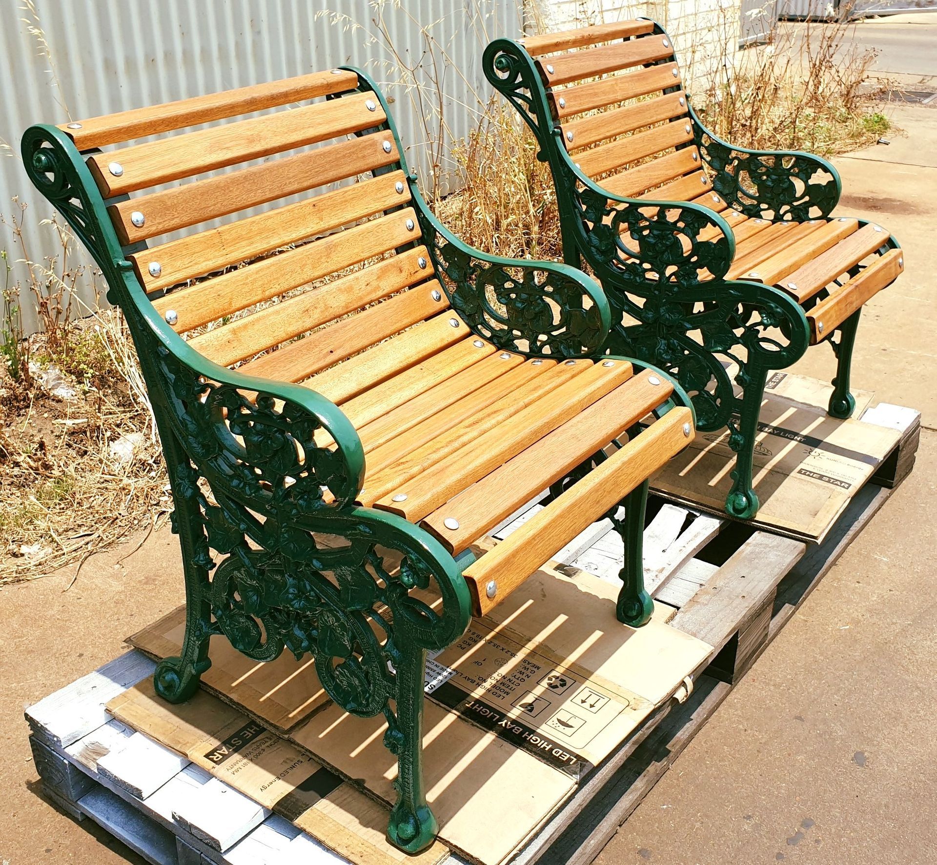 Two wooden benches are sitting on top of a cardboard pallet