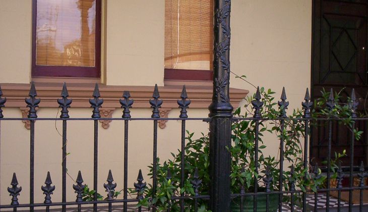 A wrought iron fence is in front of a house