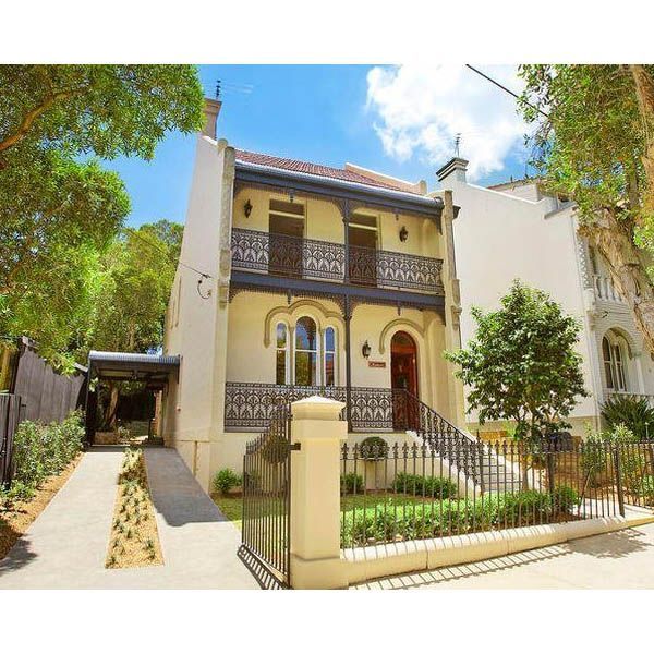 A large white house with a red door and balconies