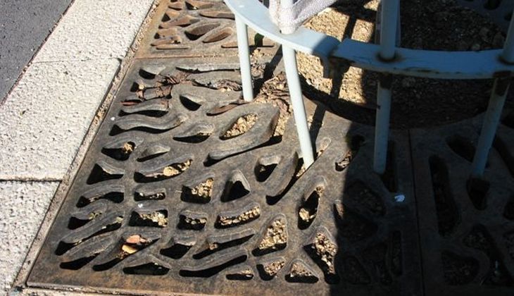 A white chair is sitting on a drain cover