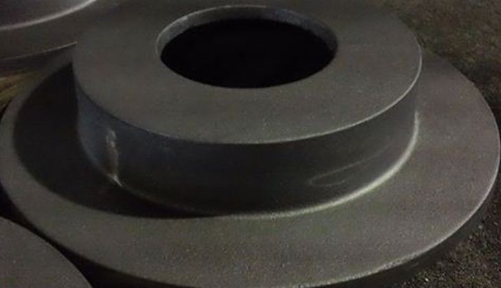 A close up of a metal disc with a hole in the middle.